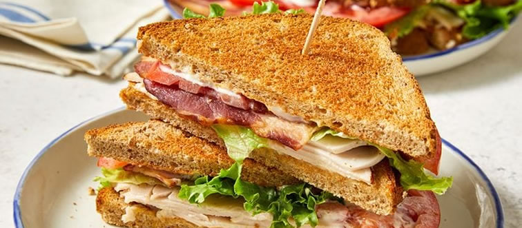 Which specific style of bread always forms the foundation of a classic Reuben sandwich?