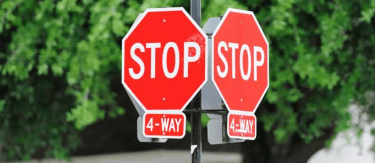 When multiple vehicles halt at a four-way stop, who gets to move forward first?