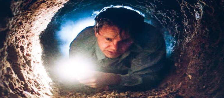 Which film follows an inmate who uses a rock hammer to tunnel out of prison and escape through a foul sewer line?